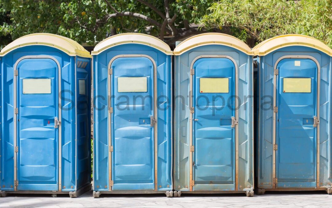 Four blue porta potties lined up in a row, providing convenient and private facilities. - How Often Do Porta Potties Need To Be Cleaned?