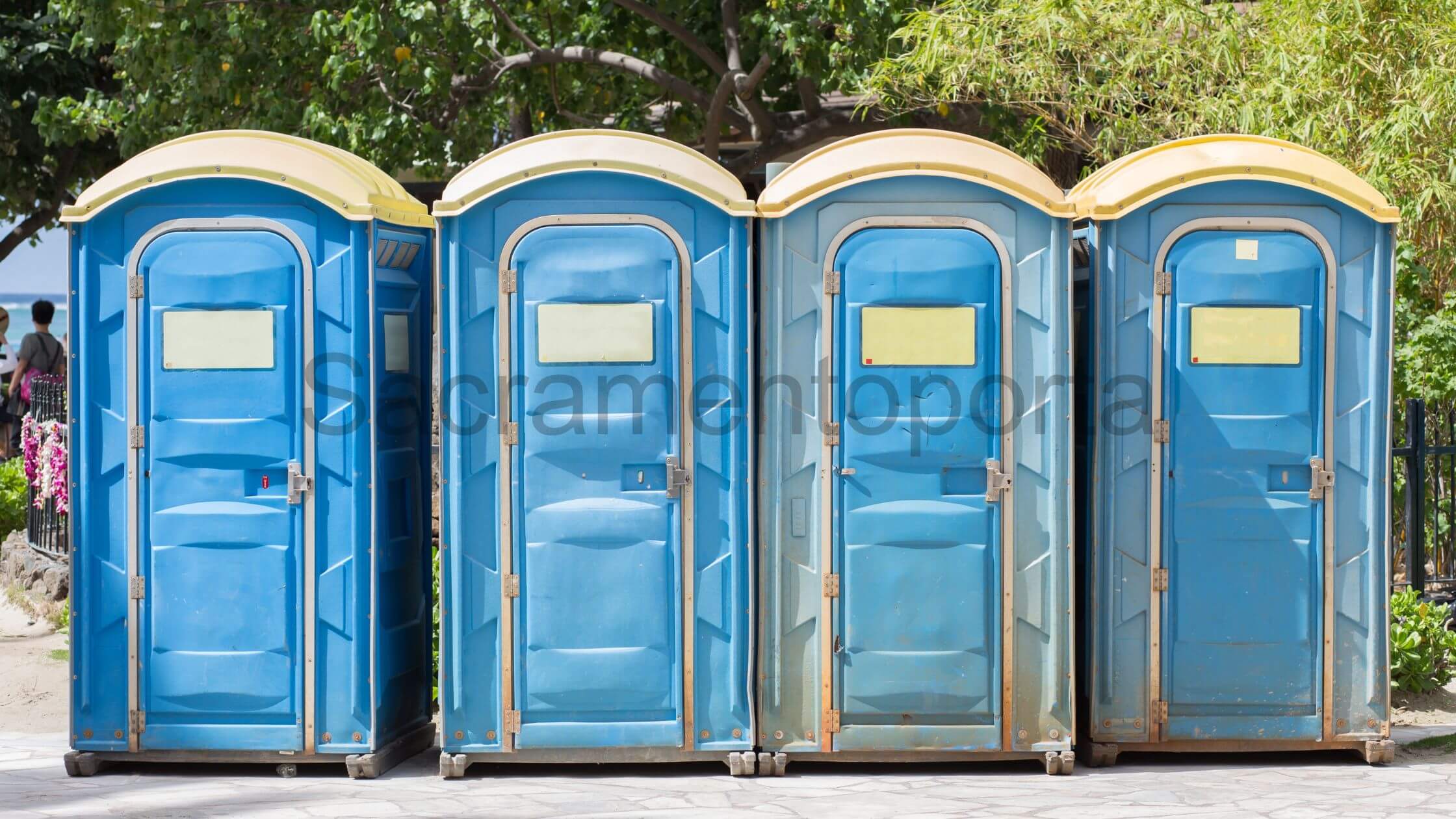 Four blue porta potties lined up in a row, providing convenient and private facilities. - How Often Do Porta Potties Need To Be Cleaned?